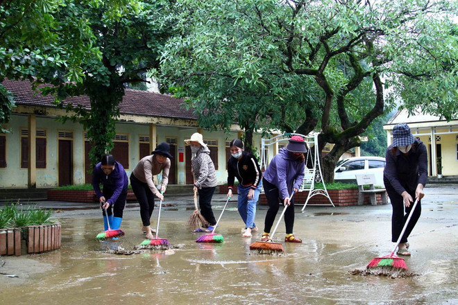 Cán bộ giáo viên trường Tiểu học Tân Hóa (huyện Minh Hóa, Quảng Bình) vệ sinh khuôn viên trường sau khi nước rút. (Ảnh: Tá Chuyên/ TTXVN) TTXVN_2109 Quang Binh khac phuc bao lu 3.jpg