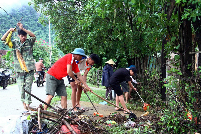 Người dân xã Tân Hóa (huyện Minh Hóa, Quảng Bình) vệ sinh đường làng, thu gom rác sau khi nước rút. (Ảnh: Tá Chuyên/TTXVN) TTXVN_2109 Quang Binh khac phuc bao lu 2.jpg