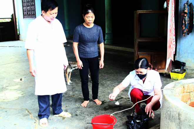 Cán bộ Trạm y tế xã Tân Hóa (huyện Minh Hóa, Quảng Bình) hướng dẫn người dân pha hóa chất Clo khử khuẩn nguồn nước sinh hoạt sau lũ. (Ảnh: Tá Chuyên/TTXVN) TTXVN_2109 Quang Binh khac phuc bao lu 4.jpg