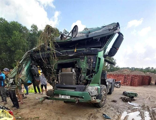 Chiếc xe tải bị bẹp dúm, biến dạng. (Ảnh: Phước Ngọc/TTXVN) Quảng Ngãi: Xe khách húc xe tải lao xuống hố sâu ven đường ảnh 1