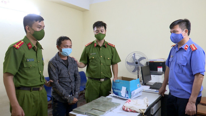 Đối tượng Giàng Bả Dế và tang vật tại cơ quan công an. (Ảnh: TTXVN phát) Sơn La: Bắt đối tượng vận chuyển ma túy, thu giữ 9 bánh nghi là heroin ảnh 1