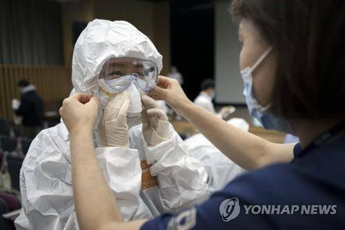 Trang bị đồ bảo hộ cho nhân viên y tế. (Nguồn: Yonhap) Hàn Quốc: Số người nhiễm COVID-19 lên 1.766, đã có 13 ca tử vong ảnh 1