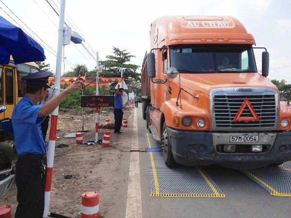 Lực lượng chức năng tiến hành kiểm soát tải trọng xe. (Ảnh: Sỹ Tuyên/TTXVN) Tổng cục trưởng Đường bộ nói về cuộc chiến chống xe quá tải ảnh 1