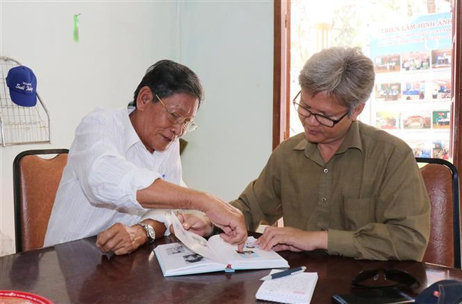 Đại úy Cao Hồng Ngọt (nguyên Đội trưởng Đội 5) giới thiệu những chiến tích được ghi trong sách của Đội 5, đơn vị hai lần được phong tặng Anh hùng Lực lượng Vũ trang nhân dân. (Ảnh: Tiến Lực/TTXVN) Vang danh Rừng Sác - Những ký ức về một thời trai trẻ ảnh 2