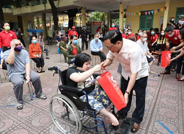 Hội Chữ thập Đỏ Việt Nam tặng quà cho người khuyết tật, người có hoàn cảnh khó khăn do dịch trên địa bàn quận Hoàn Kiếm. (Ảnh: Thanh Tùng/TTXVN) Kết luận của Ban Bí thư đối với công tác của Hội Chữ thập Đỏ ảnh 1