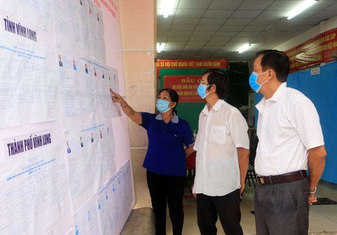 Cử tri tìm hiểu danh sách các ứng cử viên tại Trụ sở khóm Hưng Đạo Vương, phường 1, thành phố Vĩnh Long. (Ảnh: Phạm Minh Tuấn-TTXVN) Tập trung thực hiện biện pháp phòng chống dịch để bầu cử thành công ảnh 2