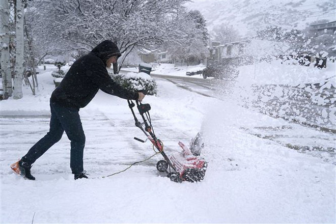 Công nhân dọn tuyết trên đường ở Provo, bang Utah, Mỹ ngày 13/12/2022. (Ảnh: AFP/TTXVN) Bão tuyết gây ảnh hưởng nghiêm trọng tại miền Bắc-Trung nước Mỹ ảnh 1