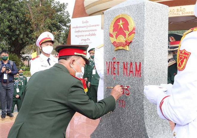 Đại tướng, Bộ trưởng Quốc phòng Lào Chansamone Chanyalath tô sơn cột mốc 605 tại cửa khẩu Lao Bảo tháng 12/2021. (Ảnh: Trọng Đức/TTXVN) Bộ Quốc phòng hai nước Lào-Việt Nam tăng cường hợp tác ảnh 1