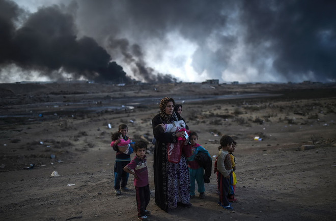 Người dân Iraq sơ tán khỏi khu vực chiến sự ở Mosul tới Qayyarah, phía nam Mosul ngày 29/10. (Nguồn: AFP/ TTXVN) IS sử dụng máy bay không người lái tấn công quân đội Iraq ở Mosul ảnh 1