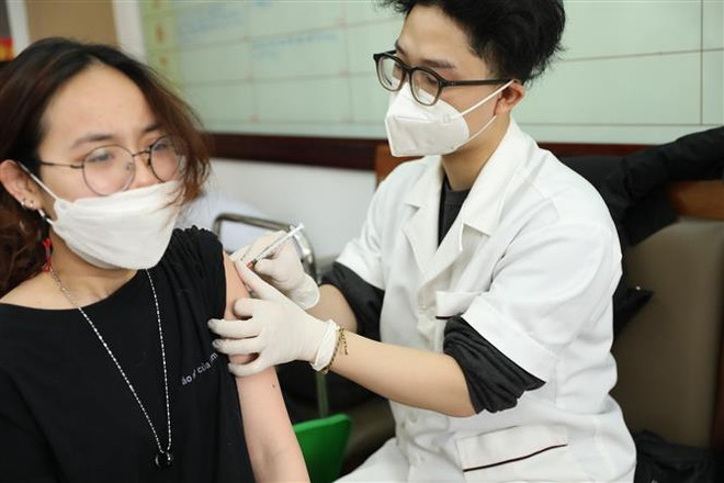 Nhân viên y tế tiêm vaccine phòng COVID-19 cho người dân phường Lê Đại Hành (quận Hai Bà Trưng). (Ảnh: Minh Quyết/TTXVN) Hà Nội: Mỗi ngày có thêm hàng chục nghìn F0 nhưng số ca nặng giảm ảnh 1