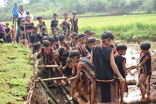 Sau lễ cúng, người dân trong làng cùng xuống giọt nước để thực hiện các nghi thức cầu may mắn. (Ảnh: TTXVN phát) Về Gia Lai tham dự lễ cúng giọt nước cầu mùa của người Jrai ảnh 1