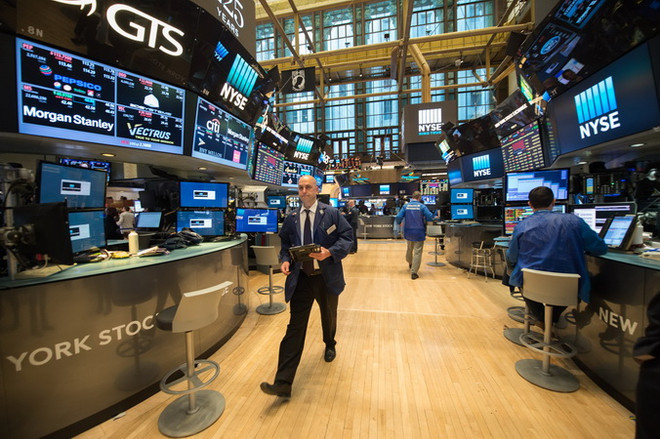 Các nhà giao dịch tại thị trường chứng khoán New York ngày 17/5. (Nguồn: AFP/TTXVN) Thị trường chứng khoán phản ứng trái chiều sau quyết định của Fed ảnh 1