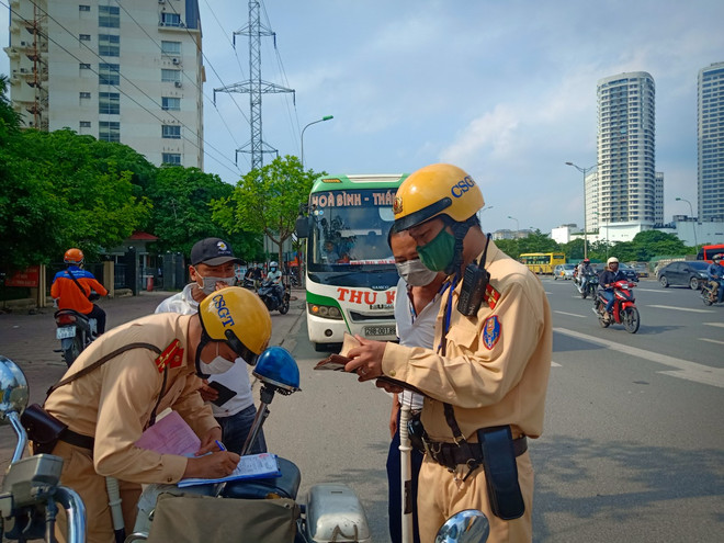 Cảnh sát giao thông xử phạt phương tiện xe khách vi phạm. (Ảnh: PV/Vietnam+) vnp-canh-sat-giao-thong-15122021-1093.jpg