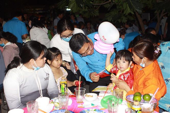 Lãnh đạo Liên đoàn Lao động TP.Hồ Chí Minh tặng quà Tết cho trẻ em và công nhân lao động không có điều kiện về quê đón Tết tại ngày hội Tết sum vầy do Liên đoàn Lao động huyện Nhà Bè phố hợp cùng các doanh nghiệp tổ chức. (Ảnh: Thanh Vũ/TTXVN) Tạo đòn bẩy cho phong trào công nhân lao động tại TP.HCM ảnh 1