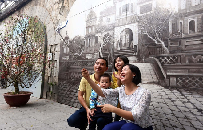 Người dân thủ đô chụp ảnh lưu niệm tại phố Bích họa Phùng Hưng. (Ảnh: Danh Lam/TTXVN) Kiến tạo các không gian sáng tạo độc đáo, mới lạ cho Hà Nội ảnh 2