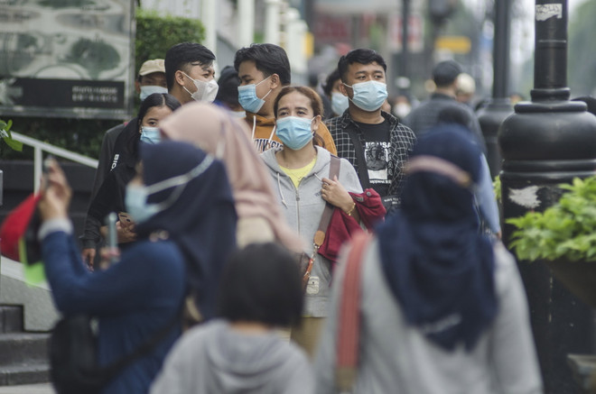 Người dân đeo khẩu trang phòng lây nhiễm COVID-19 tại Bandung, Indonesia. (Ảnh: THX/TTXVN) Indonesia ghi nhận ngày có số ca mắc mới thấp nhất trong hơn 1 năm ảnh 1