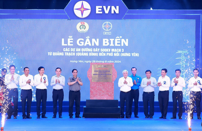 Thủ tướng Phạm Minh Chính và các đại biểu thực hiện nghi thức gắn biển công trình đường dây 500 kV mạch 3 Quảng Trạch-Phố Nối. (Ảnh: Dương Giang/TTXVN) ttxvn_thu_tuong_du_le_khanh_thanh_du_an_duong_day_500kv_mach_3_quang_trach_-_pho_noi_14.jpg