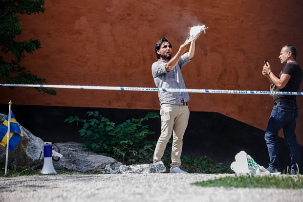 Đối tượng Salwan Momika đốt kinh Koran trước đền thờ Hồi giáo lớn nhất ở thủ đô Stockholm hôm 28/6. (Ảnh: EPA) Ngoại trưởng Thụy Điển lấy làm tiếc về hành vi báng bổ kinh Koran ảnh 1