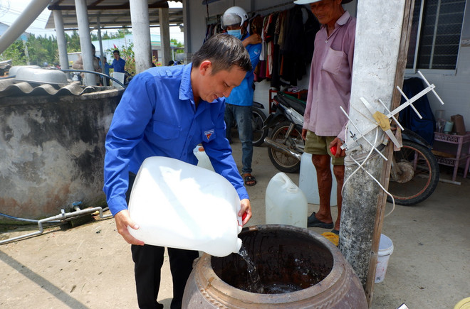 Đoàn viên thanh niên huyện Cần Giuộc mang nước đến tận nhà cho gia đình chính sách, người già neo đơn vào thời điểm hạn mặn. (Ảnh: Đức Hạnh/TTXVN) TTXVN_1604hanhan3.jpg
