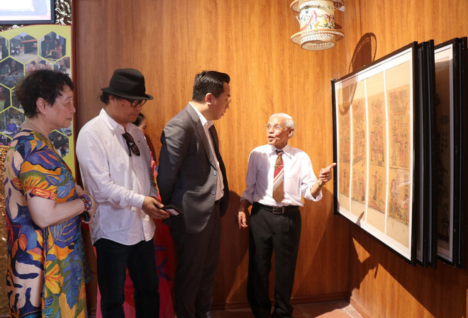 Nghệ sỹ ưu tú Nguyễn Đăng Chế (ngoài cùng bên phải) giới thiệu nhà trưng bày cho các du khách. (Ảnh: Thái Hùng/TTXVN) TTXVN_1604tranhdangiandongho2.jpg
