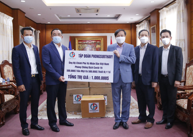 Chủ tịch Tập đoàn Phongsubthavy của Lào, ông Phongsavath Senaphuan (trái) đang trao tượng trưng tấm biển số tiền và vật tư y tế trị giá 1 triệu USD cho Đại sứ Nguyễn Bá Hùng để ủng hộ Quỹ phòng chống COVID-19 của Việt Nam. (Ảnh: Phạm Kiên/TTXVN) Một tập đoàn của Lào ủng hộ quỹ phòng chống dịch Việt Nam 1 triệu USD ảnh 1