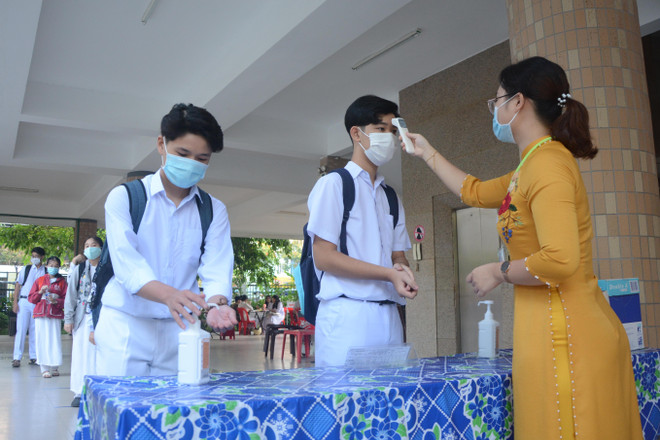 Học sinh trường THPT Phan Châu Trinh đo thân nhiệt, sát khuẩn trước khi vào lớp. (Ảnh: Văn Dũng/TTXVN) Đà Nẵng đảm bảo an toàn cho học sinh trong ngày đầu đi học lại ảnh 1