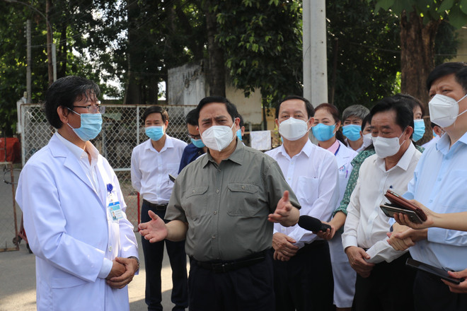 Đoàn công tác của Chính phủ do Thủ tướng Chính phủ Phạm Minh Chính dẫn đầu kiểm tra công tác phòng, chống dịch và điều trị bệnh nhân COVID-19 tại Bệnh viện Đa khoa tỉnh Bình Dương. (Ảnh: TTXVN phát) 'Chủ động, linh hoạt các giải pháp để thực hiện cho được mục tiêu kép' ảnh 2