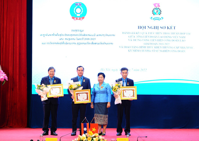 Bà Aly Vong Nor Bun Tham - Ủy viên Trung ương Đảng Nhân dân Cách mạng Lào, Chủ tịch Trung ương Liên hiệp Công đoàn Lào trao tặng Huân, Huy chương hữu nghị Lào cho Chủ tịch Tổng Liên đoàn Lao động Việt Nam Nguyễn Đình Khang. (Ảnh: Minh Đức/TTXVN) Việt Nam-Lào tăng cường hợp tác đào tạo, bồi dưỡng cán bộ công đoàn ảnh 1