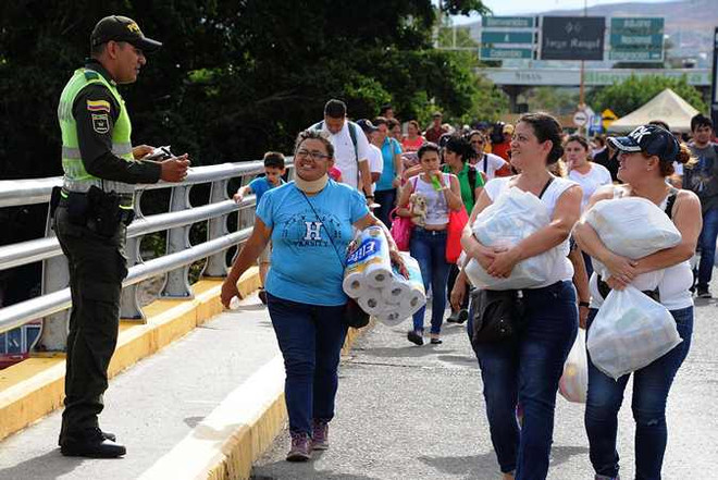 Người dân Venezuela trở về San Antonio de Tachira sau khi qua cửa khẩu biên giới tới Cucuta, Colombia mua hàng hóa thiết yếu ngày 17/7. (Nguồn: AFP/TTXVN) Colombia: Việc mở cửa biên giới với Venezuela diễn ra an toàn ảnh 1