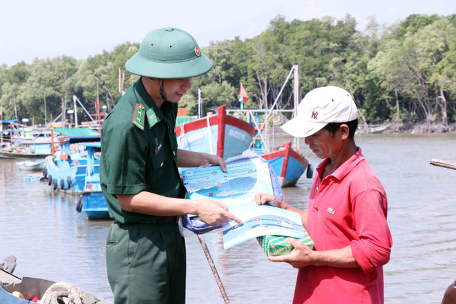Trung úy Đậu Xuân Duy, đồn Biên phòng Long Hòa, Bộ đội Biên phòng Thành phố Hồ Chí Minh tuyên truyền phổ biến kiến thức pháp luật cho đồng bào làm nghề đánh bắt hải sản trên biển. (Ảnh: Xuân Khu/TTXVN) Chuyện về những người lính quân hàm xanh ở Thành phố Hồ Chí Minh ảnh 3