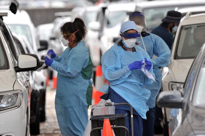 Nhân viên y tế lấy mẫu xét nghiệm COVID-19 cho người dân tại Sydney, Australia. (Ảnh: AFP/TTXVN) Số ca mắc mới COVID-19 tăng cao tại Australia và New Zealand ảnh 1