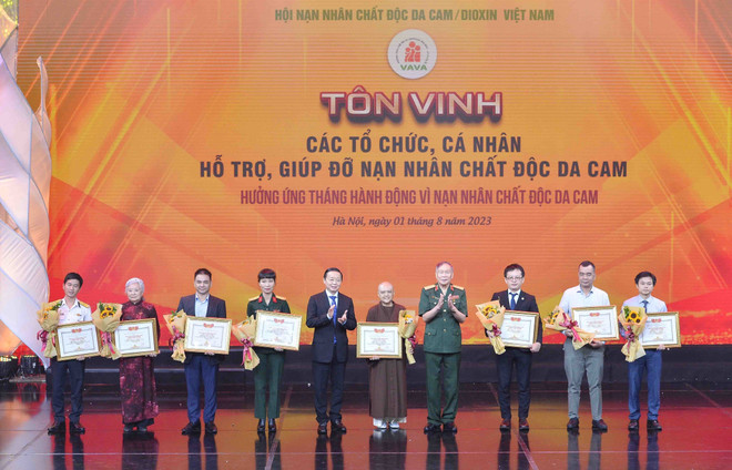 Phó Thủ tướng Trần Hồng Hà, Thượng tướng Nguyễn Văn Rinh - Chủ tịch hội Nạn nhân chất độc da cam/dioxin Việt Nam - trao Bằng tri ân tấm lòng vàng vì nạn nhân chất độc da cam cho các tập thể và nhà hảo tâm. (Ảnh: Minh Đức/TTXVN) 'Thắp lửa niềm tin' giúp nạn nhân da cam vững tin trong cuộc sống ảnh 1