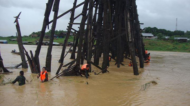 Binh sỹ Thái Lan nỗ lực giải phóng dòng chảy dưới chân cầu Mon. (Nguồn: floodlist.com) Cây cầu gỗ dài nhất của Thái Lan có nguy cơ bị sập đổ do mưa lũ ảnh 1
