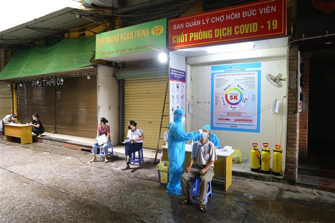Tất cả nhân viên và tiểu thương chợ Hôm - Đức Viên đều được lấy mẫu xét nghiệm theo phương pháp RT-PCR. (Ảnh: Hoàng Hiếu/TTXVN) Ngày 25/9: Số ca tử vong giảm mạnh, đã có hơn nửa triệu ca khỏi bệnh ảnh 1