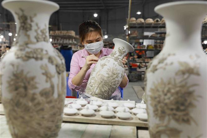 Công ty Gốm sứ cổ truyền Bảo Quang (xã Bát Tràng, huyện Gia Lâm) mỗi năm sản xuất khoảng 10.000 bộ sản phẩm gốm tâm linh, doanh thu 50 tỷ đồng, tạo việc làm ổn định cho 500 lao động tại địa phương. (Ảnh: Vũ Sinh/TTXVN) Nông thôn mới Hà Nội: Gìn giữ nét riêng văn hóa đất Thăng Long ảnh 1