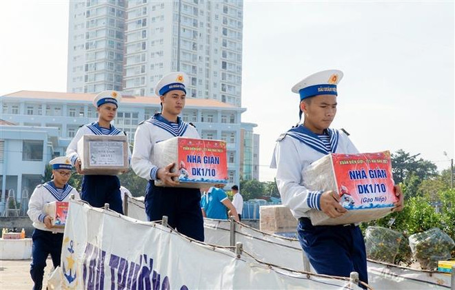 Chuyển quà Tết lên tàu. (Ảnh: Đoàn Mạnh Dương/TTXVN) Mang hương vị Tết đến cán bộ-chiến sỹ Nhà giàn DK1, tàu trực trên biển ảnh 1