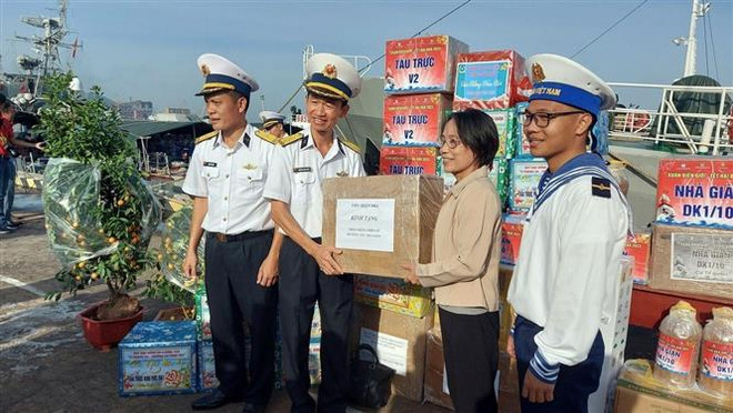 Tiếp nhận quà Tết đưa đi trao tặng. (Ảnh: Đoàn Mạnh Dương/TTXVN) Mang hương vị Tết đến cán bộ-chiến sỹ Nhà giàn DK1, tàu trực trên biển ảnh 2