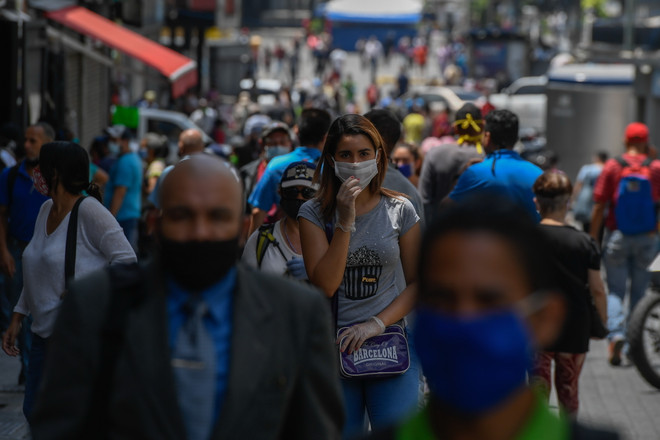 Người dân đeo khẩu trang phòng lây nhiễm COVID-19 tại Caracas, Venezuela. (Ảnh: AFP/TTXVN) Dịch COVID-19 sáng 24/6: Kiểm tra nghiêm ngặt hành khách rời Bắc Kinh ảnh 1