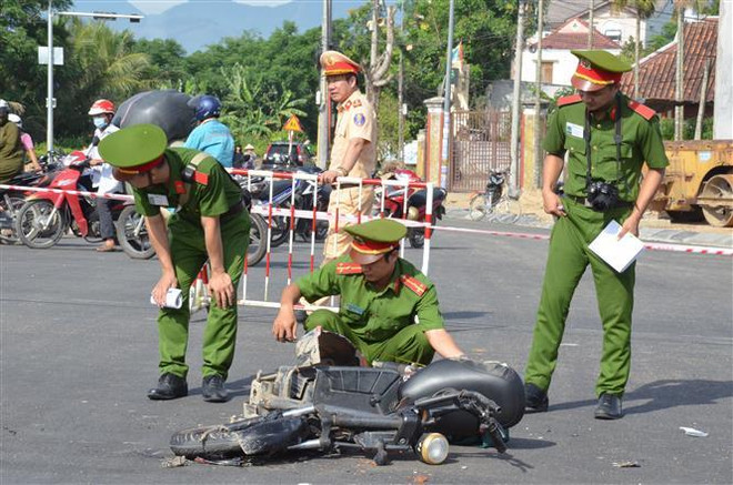 Lực lượng chức năng làm việc tại hiện trường vụ tai nạn. (Ảnh: TTXVN) Nữ sinh lớp 12 bị xe tải đâm tử vong trên đường đi ôn thi tốt nghiệp ảnh 1