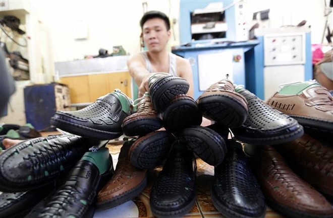 Sản xuất giầy xuất khẩu tại cơ sở Chí Cương, thị trấn Đồng Văn, huyện Duy Tiên, tỉnh Hà Nam. (Ảnh: Trần Việt/TTXVN) Cuộc chiến thương mại Mỹ-Trung và cơ hội cho kinh tế Việt Nam ảnh 1