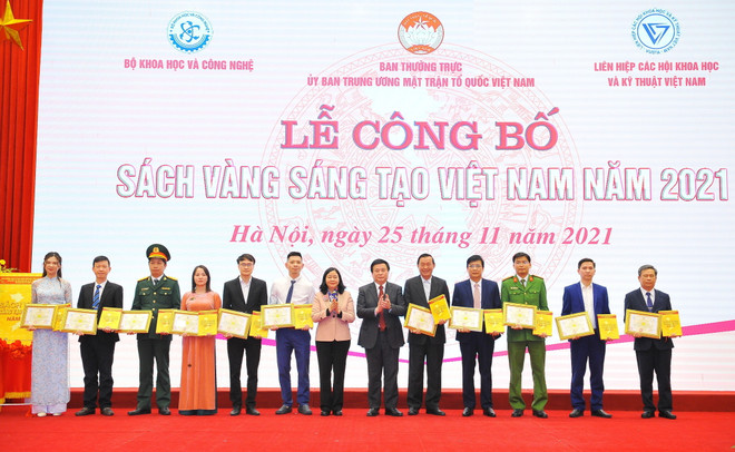 Giám đốc Học viện Chính trị Quốc gia Hồ Chí Minh, Chủ tịch Hội đồng Lý luận Trung ương Nguyễn Xuân Thắng và Bí thư Trung ương Đảng, Trưởng Ban Dân vận Trung ương Bùi Thị Minh Hoài trao Giấy chứng nhận cho các cá nhân. (Ảnh: Minh Đức/TTXVN) Vinh danh các công trình tiêu biểu trong Sách vàng Sáng tạo Việt Nam ảnh 3