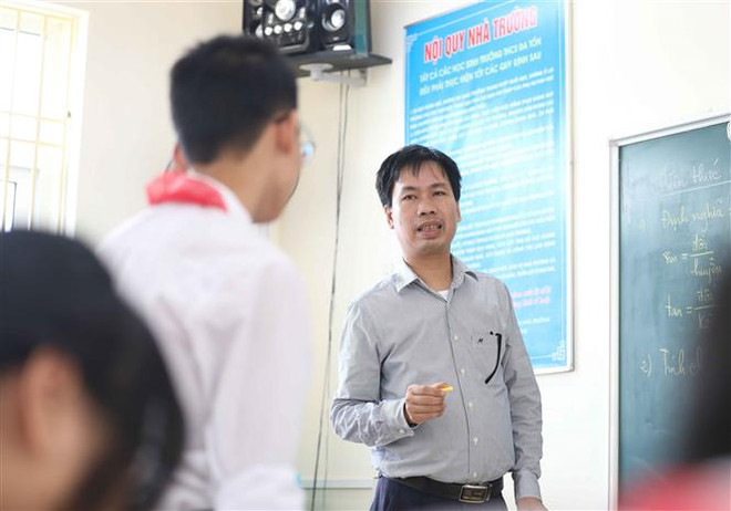 Thầy giáo Nguyễn Đức Trường trong một giờ lên lớp với học sinh lớp 9, trường THCS Đa Tốn, huyện Gia Lâm (Hà Nội). (Ảnh: Thanh Tùng/TTXVN) Công dân Thủ đô ưu tú: Người thầy nghị lực gieo niềm đam mê Toán học ảnh 1
