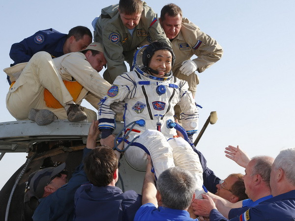 Nhân viên cơ quan vũ trụ Nga hỗ trợ nhà du hành Nhật Bản Koichi Wakatasau rời khỏi tàu Soyuz TMA-11 khi con tàu này hạ cánh xuống thảo nguyên gần Dzhezkazgan. (Nguồn: AFP/TTXVN) 3 nhà du hành trong đội bay MKS-38 trở về Trái Đất an toàn ảnh 1