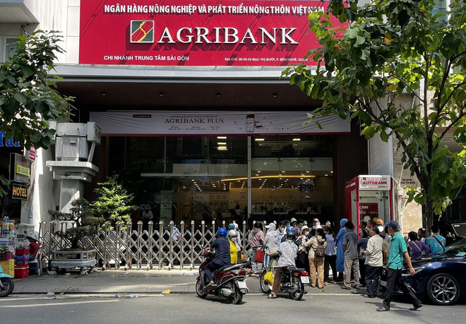 Ngân hàng thương mại Agribank Chi nhánh Trung tâm Sài Gòn trên đường Mạc Thị Bưởi (quận 1, Thành phố Hồ Chí Minh) phải đóng cửa sớm do lượng người đến mua vàng quá đông. (Ảnh: Thanh Vũ/TTXVN) ttxvn_tp_ho_chi_minh_nguoi_mua_vang_mieng_sjc_tiep_tuc_tang_1306-1.jpg