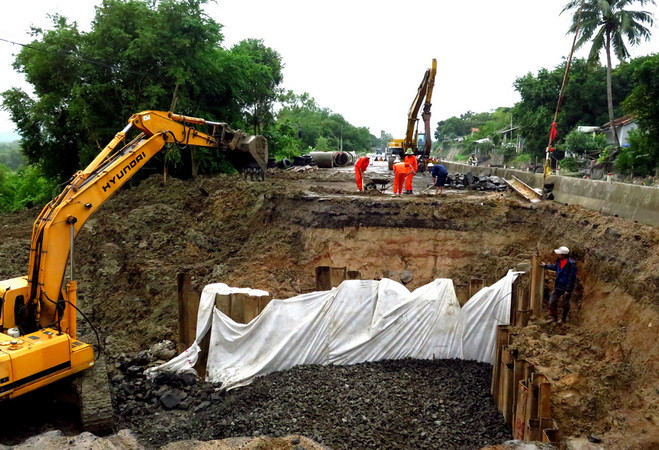 Một nửa mặt đường Quốc lộ 1 bị sạt lở nghiêm trọng đang được các đơn vị khẩn trương thi công. (Ảnh: Thế Lập/TTXVN) Quốc lộ 1 đoạn qua Phú Yên bị hỏng nghiêm trọng do mưa lớn ảnh 1