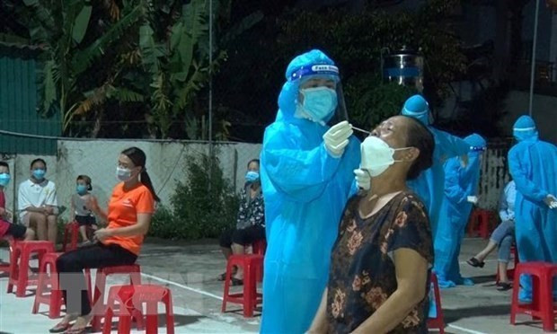 Nhân viên y tế Nghệ An lấy mẫu xét nghiệm cho người dân. (Ảnh: Văn Tý/TTXVN) Nghệ An: Phát huy vai trò làm gương, vận động nhân dân chống dịch ảnh 1