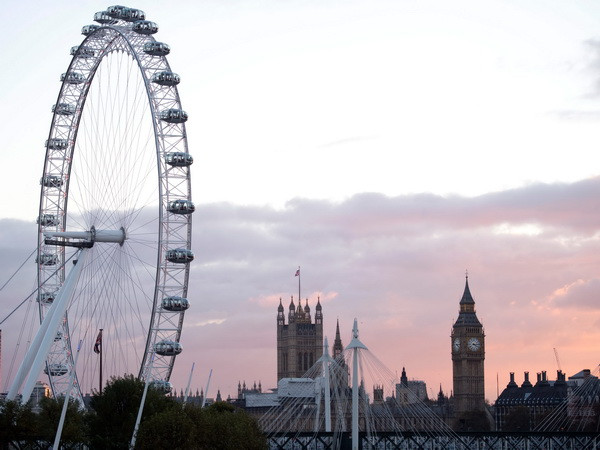 Tháp Elizabeth (phải) và Vòng quay Thiên niên kỷ (London Eye ) tại thủ đô London. (Nguồn: AFP/TTXVN) Các doanh nghiệp Anh có thể ngừng hoặc hủy hơn 65 tỷ bảng đầu tư ảnh 1