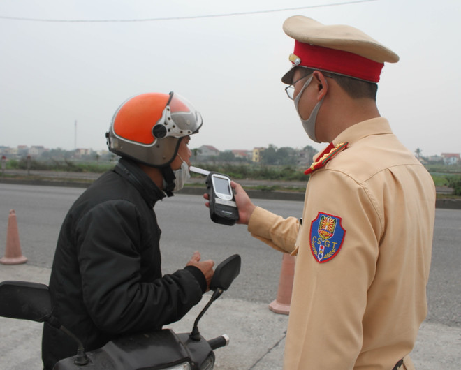 Cảnh sát giao thông kiểm tra nồng độ cồn của người điều khiển phương tiện. (Ảnh: Thùy Dung/TTXVN) Tai nạn giao thông giảm nhưng vi phạm nồng độ cồn còn xảy ra phổ biến ảnh 1