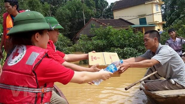 Cán bộ Hội Chữ thập Đỏ Việt Nam cứu trợ người dân vùng lũ. (Ảnh: PV/Vietnam+) Hội Chữ thập Đỏ Việt Nam-Trung Quốc tăng kết nối hoạt động nhân đạo ảnh 1