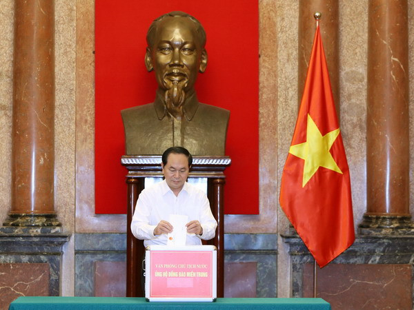 Chủ tịch nước Trần Đại Quang quyên góp ủng hộ đồng bào miền Trung. (Ảnh: Nhan Sáng/TTXVN) Văn phòng Trung ương Đảng và Chủ tịch nước ủng hộ đồng bào lũ lụt ảnh 1